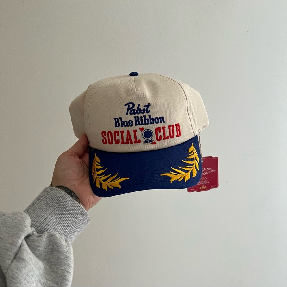 American Needle Cream and Blue Cap